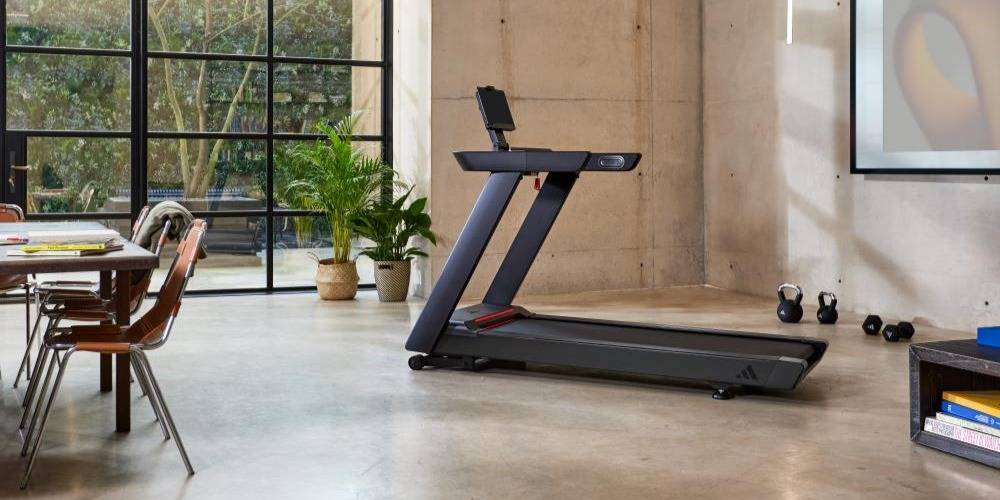 Adidas löpband i modern vardagsrum med stora fönster